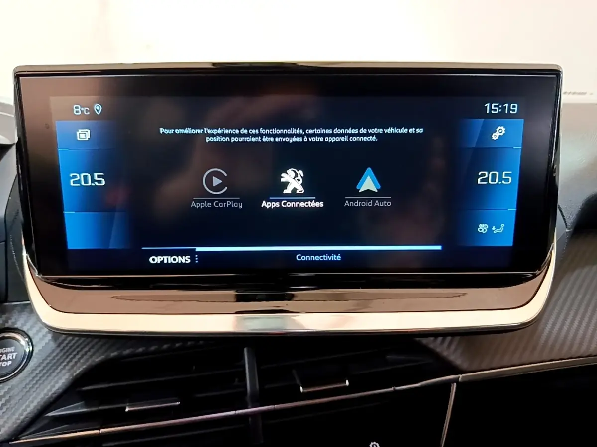 Écran tactile central affichant Apple CarPlay et Android Auto dans le tableau de bord d’un Peugeot 2008 orange.