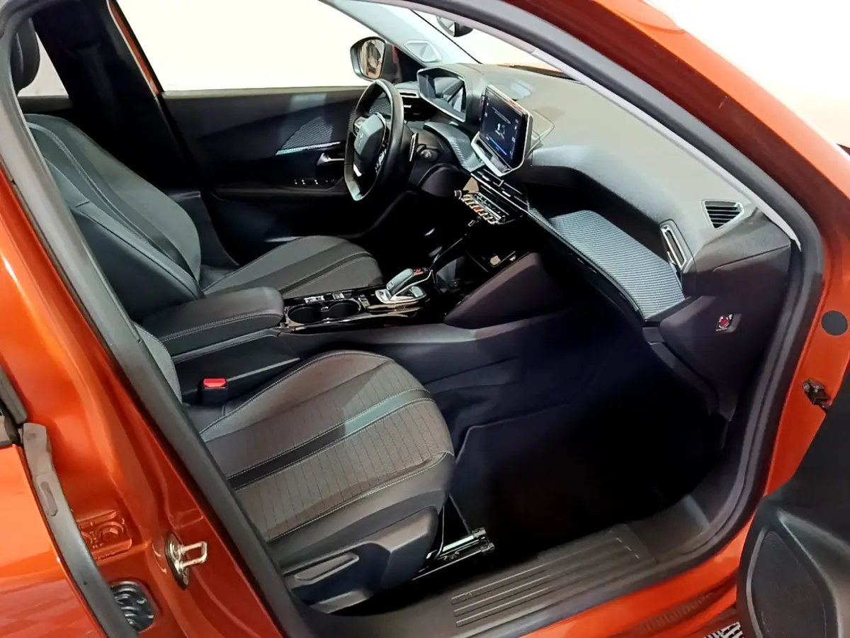 Intérieur avant droit du Peugeot 2008 orange 2021, avec tableau de bord numérique et écran tactile central.