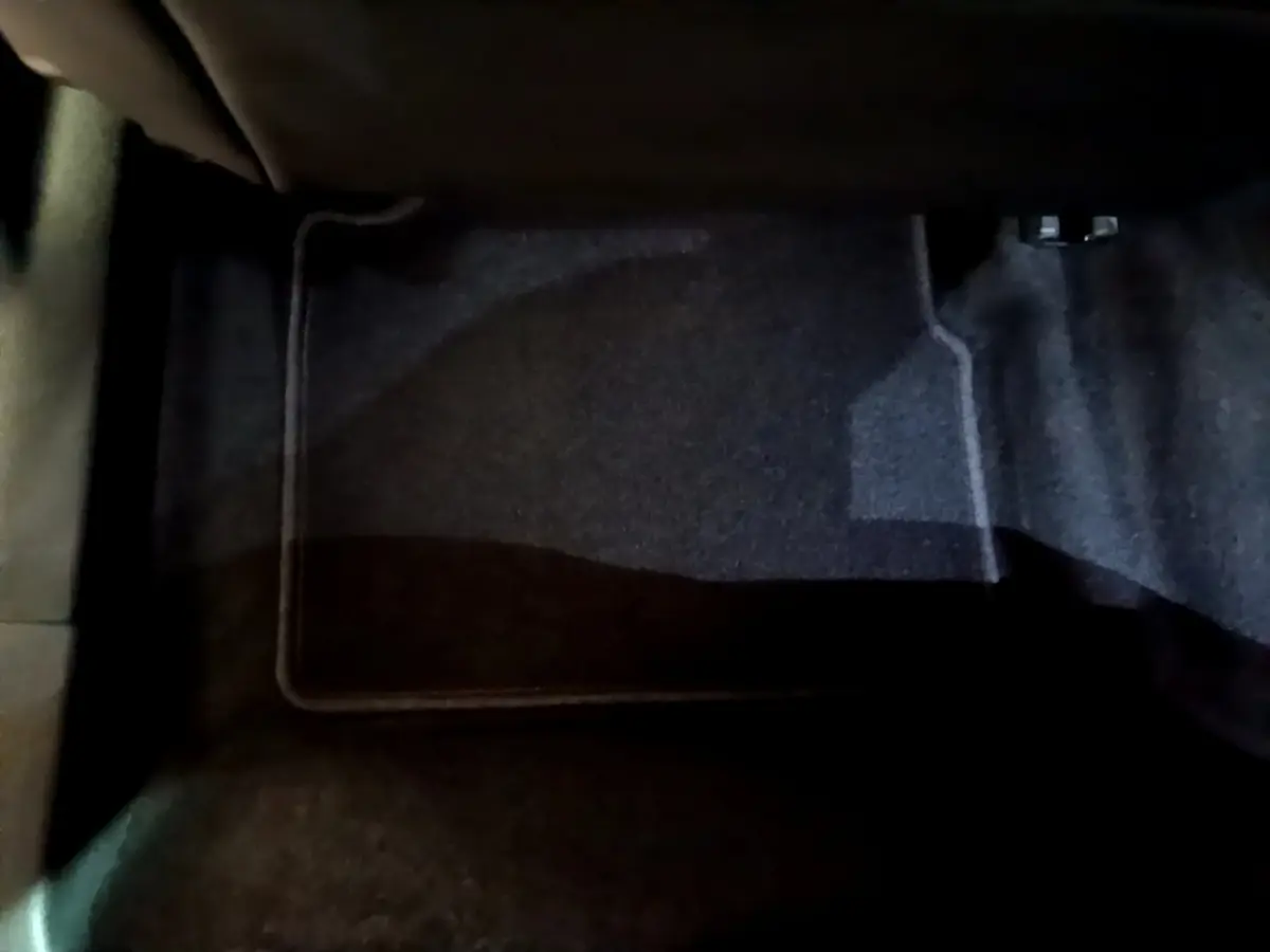 Vue rapprochée du tapis de sol noir côté passager avant du Peugeot 2008 orange 2021 PureTech 130 Allure Business.