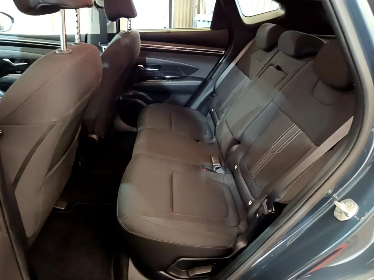 Vue intérieure côté droit des sièges arrière noirs du Hyundai Tucson 2023 bleu hybride rechargeable.