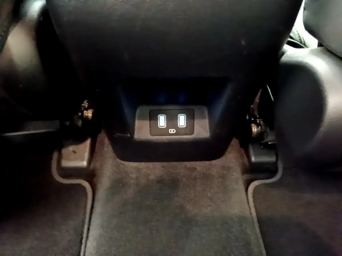 Vue rapprochée des prises USB arrière sous les sièges noirs du Hyundai Tucson bleu 2023 hybride rechargeable.