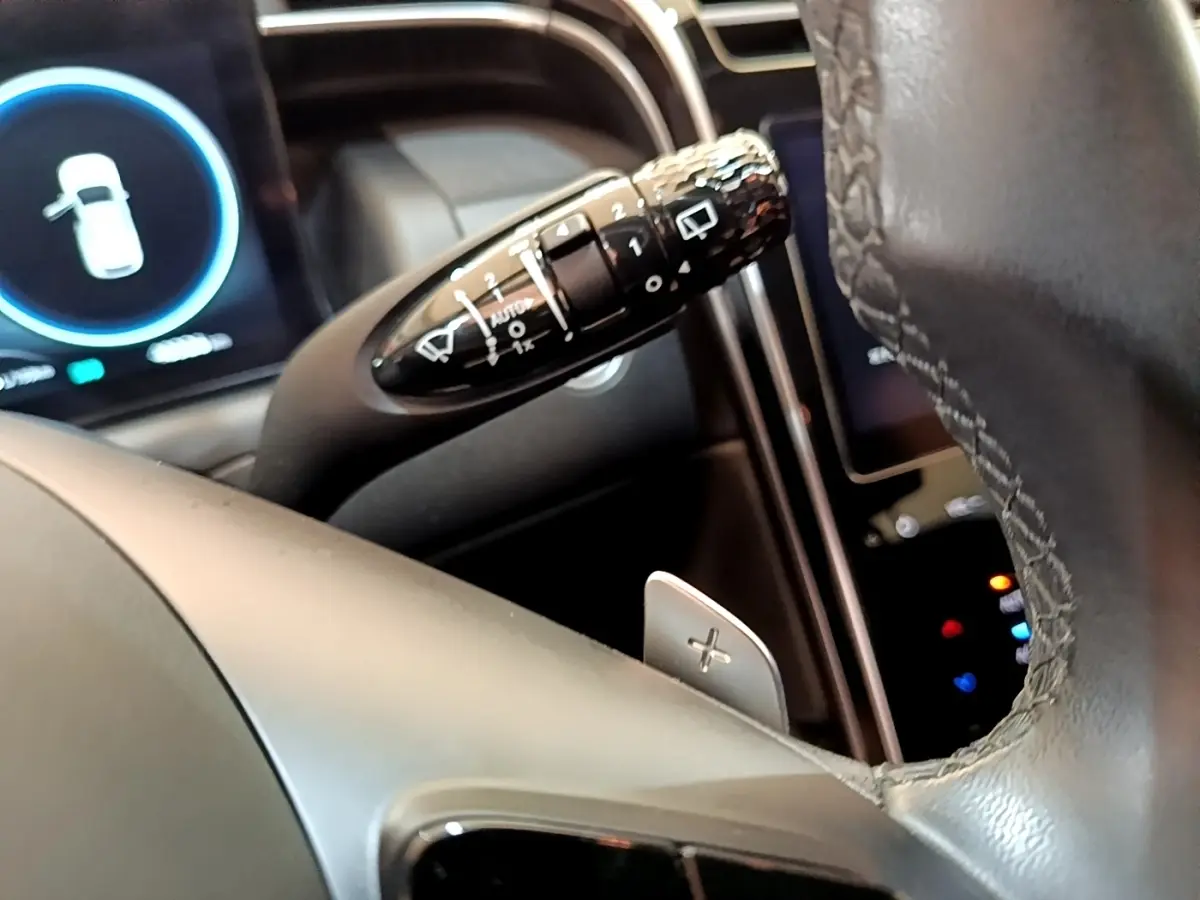 Gros plan sur la manette de commande des essuie-glaces côté gauche du volant cuir du Hyundai Tucson bleu 2023.
