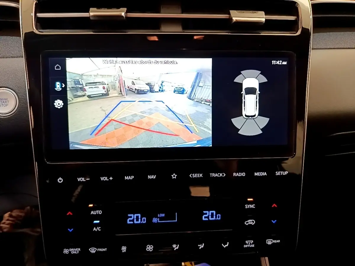 Écran tactile central affichant la caméra de recul et les capteurs de stationnement du Hyundai Tucson bleu 2023.