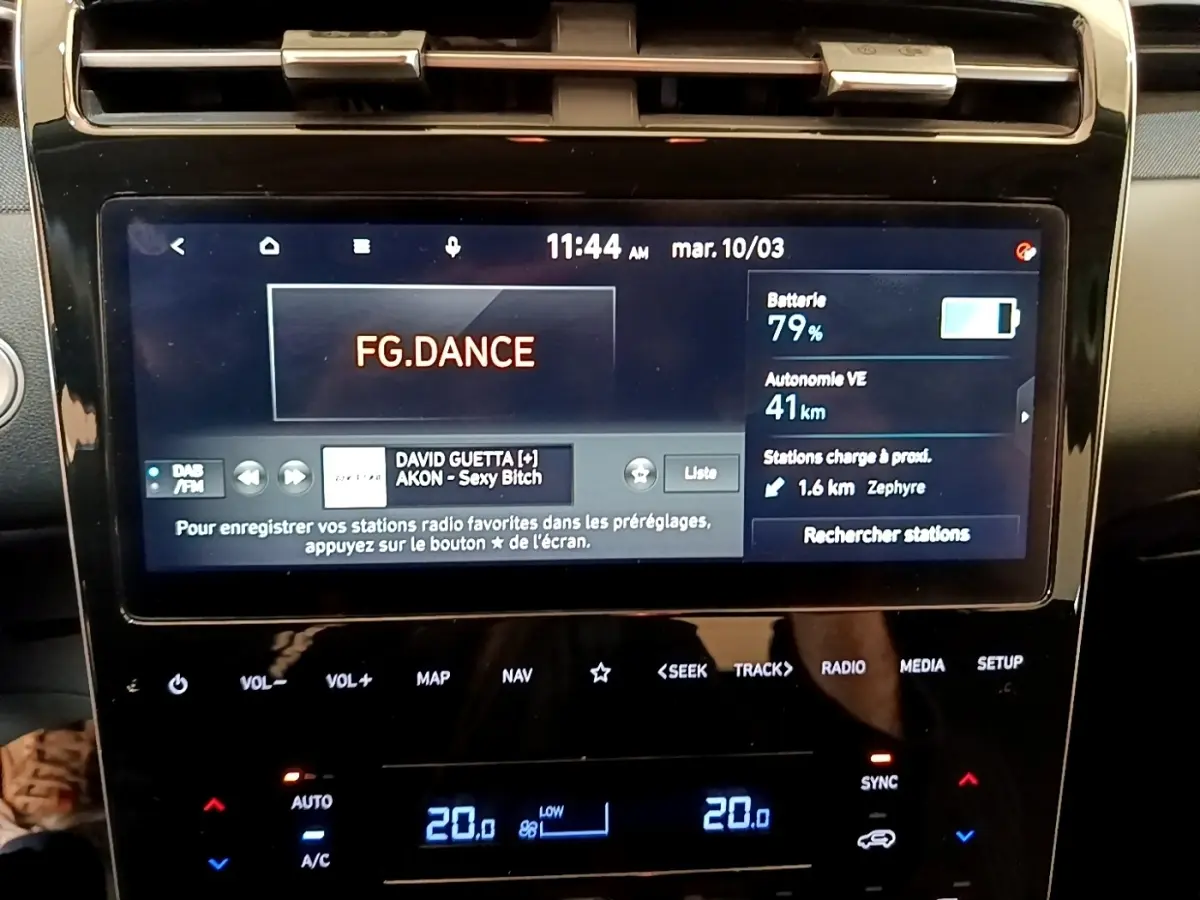 Écran tactile central du Hyundai Tucson bleu 2023 affichant radio et autonomie batterie à 79%