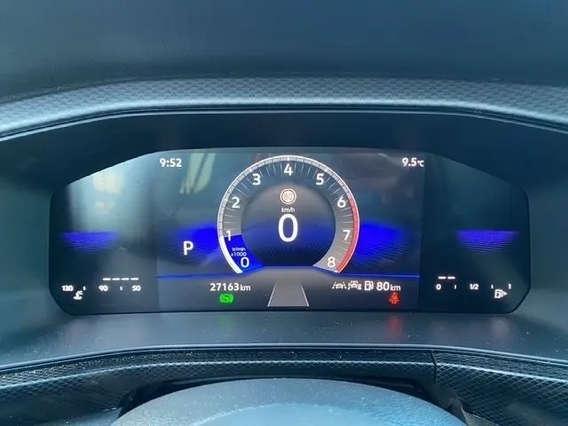 Vue rapprochée du combiné d'instruments numérique du Volkswagen T-Cross noir, affichant la vitesse à 0 km/h et 27 163 km au compteur.