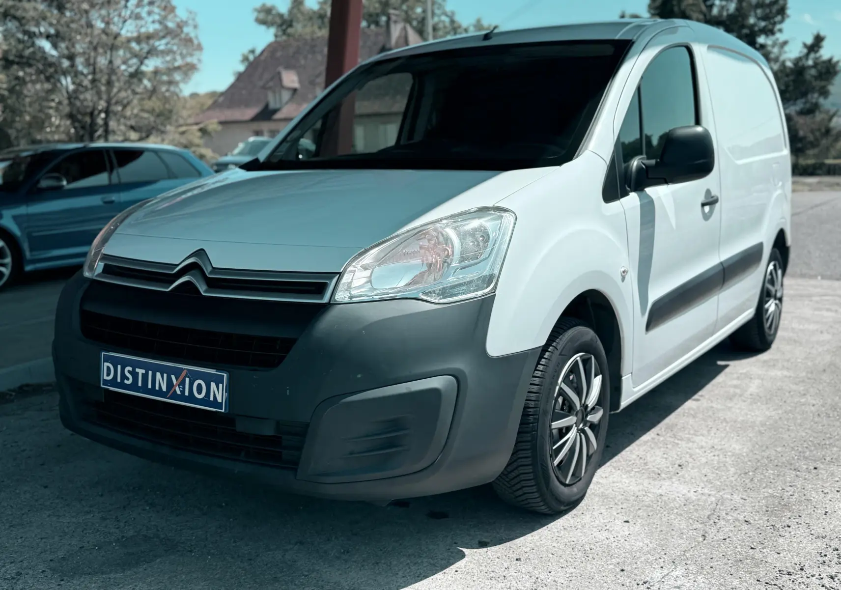 Vue 3/4 avant droite d’un Citroën Berlingo blanc 2016 avec pare-chocs noir et jantes alliage.