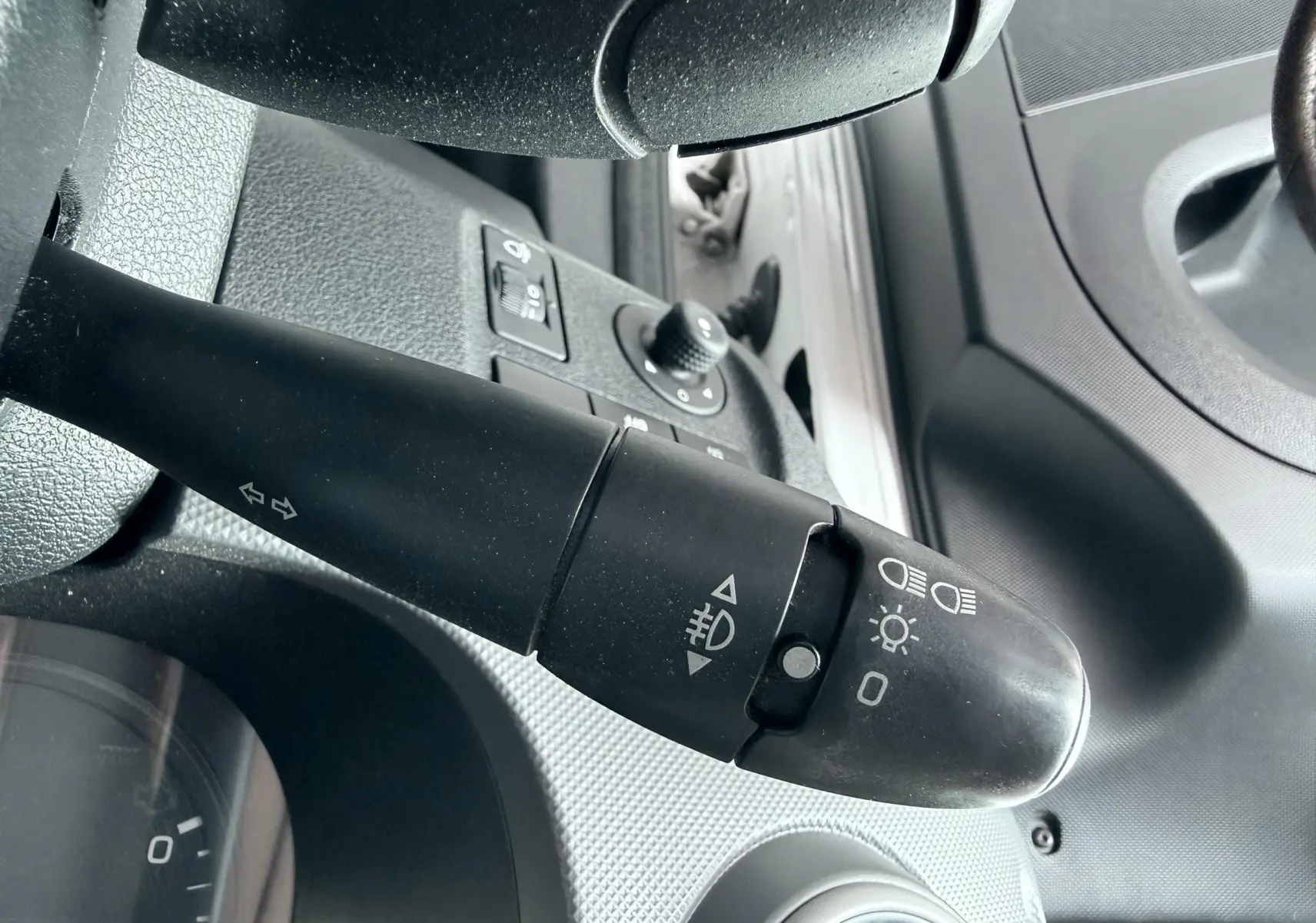 Gros plan sur la commande des phares et clignotants côté gauche du tableau de bord d'un Citroën Berlingo blanc 2016.