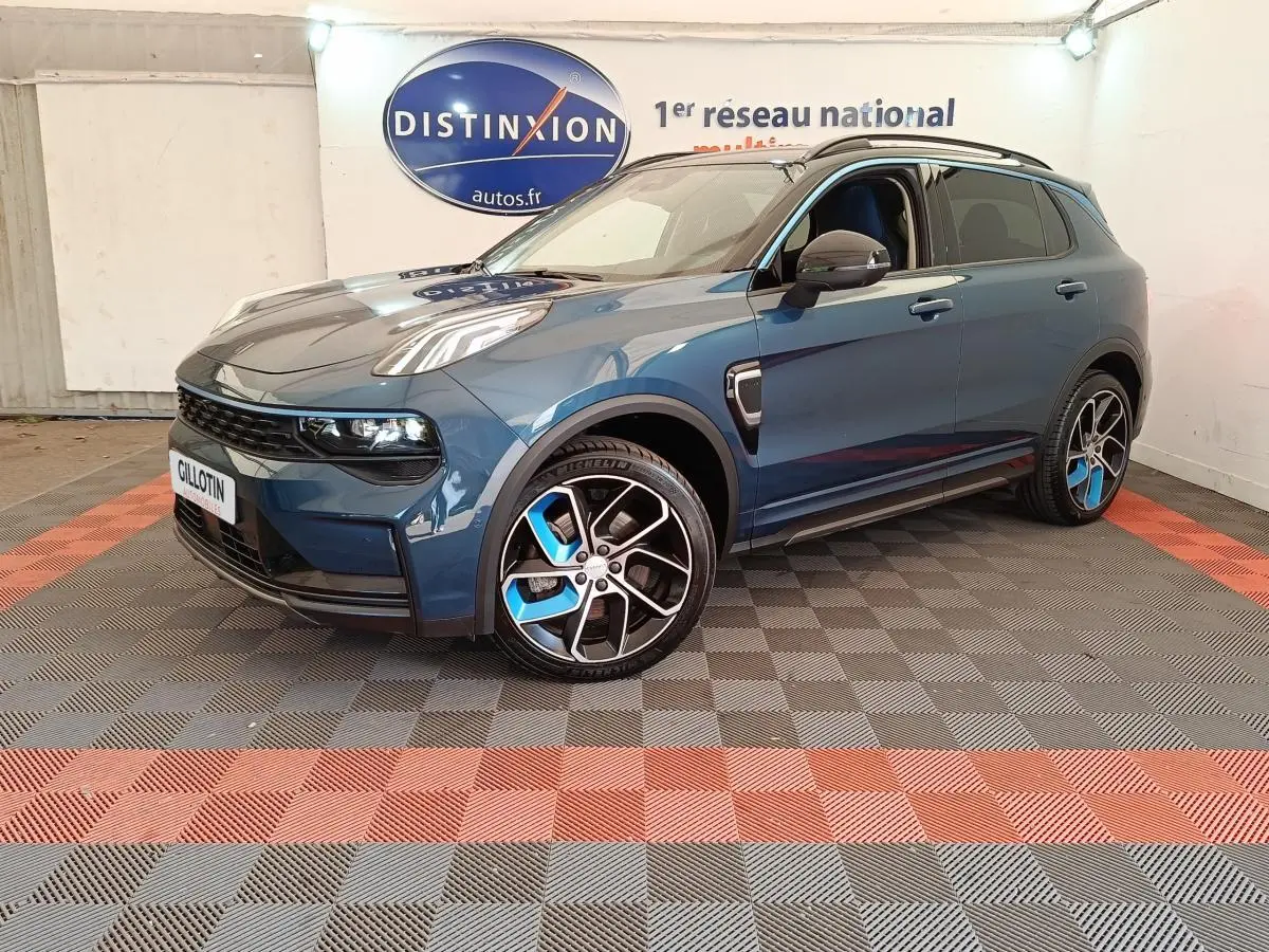 Vue 3/4 avant droite du SUV LINK & CO 01 bleu avec jantes bicolores et phares LED dans un showroom.