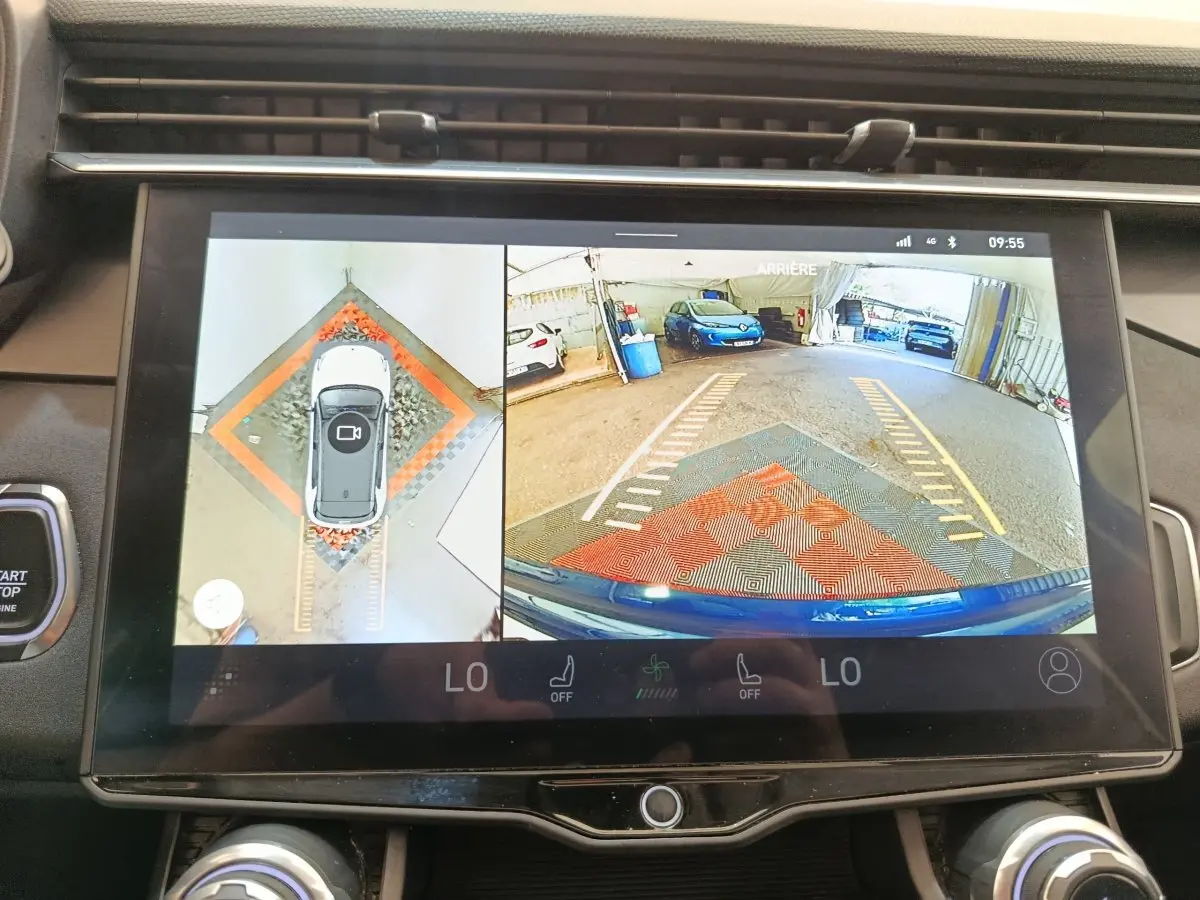 Écran tactile affichant la caméra 360° et vue arrière d’un LINK & CO 01 bleu en stationnement dans un garage.