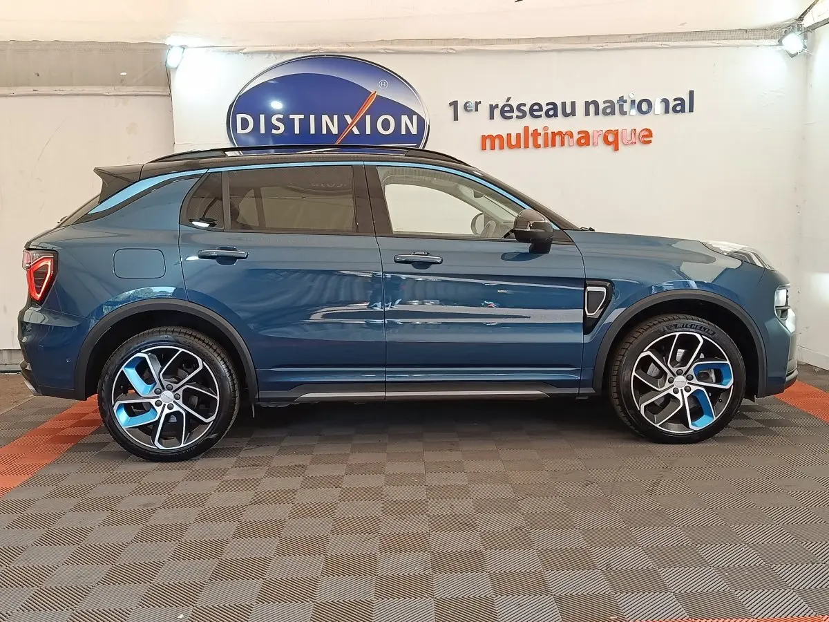 Vue de profil côté gauche d'un SUV Link & Co 01 hybride rechargeable bleu avec jantes bicolores et toit noir.
