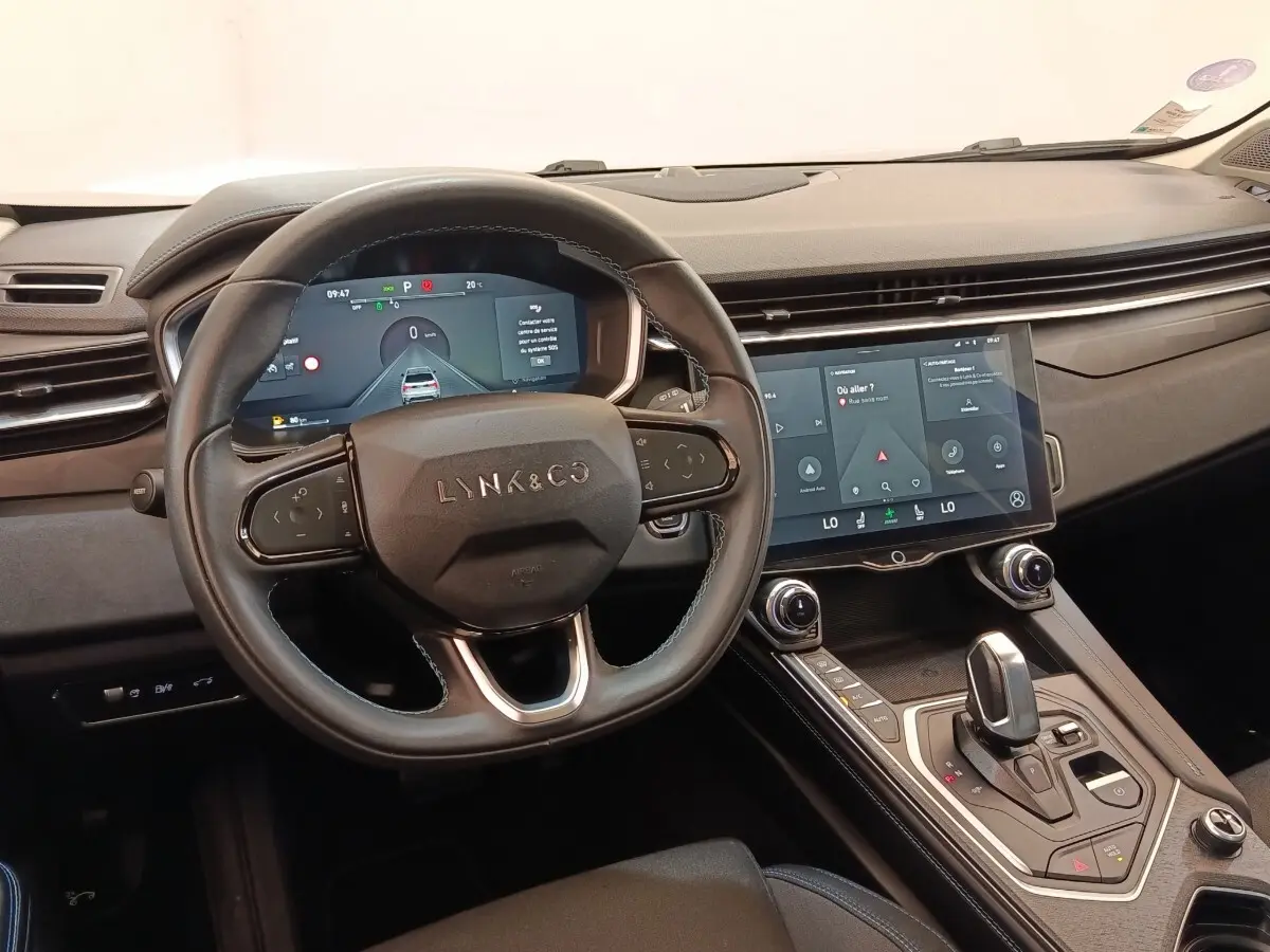 Vue intérieure centrée sur le volant et la console centrale tactile du Lynk & Co 01, finition noire moderne.
