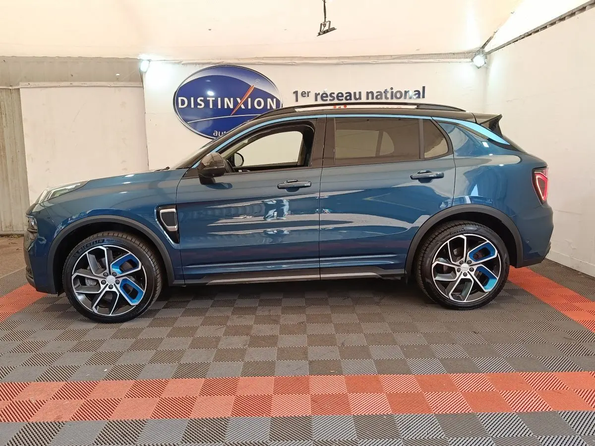 Vue de profil côté gauche du SUV Link & Co 01 hybride rechargeable bleu, avec jantes alliage bicolores et toit noir.