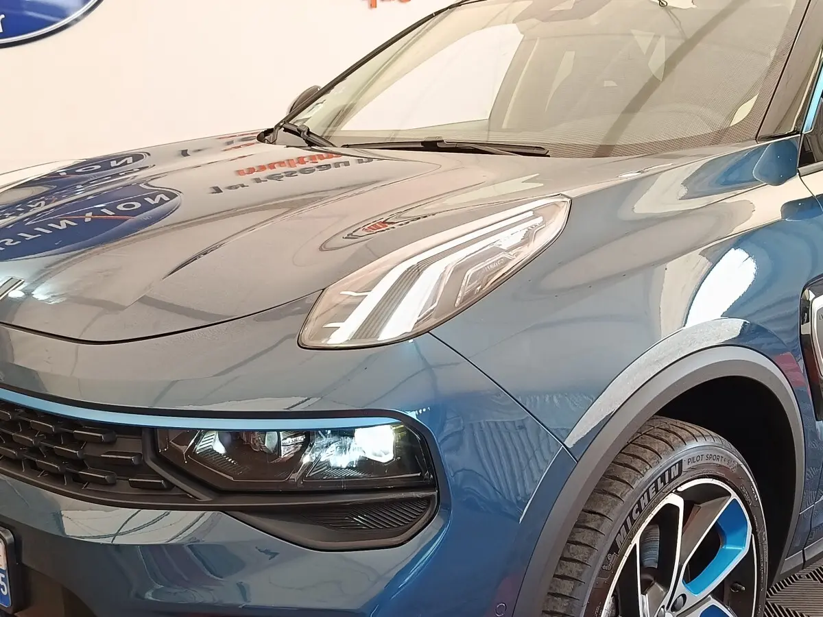 Vue 3/4 avant droit du SUV Link & Co 01 bleu avec phares LED et jantes bicolores distinctives.