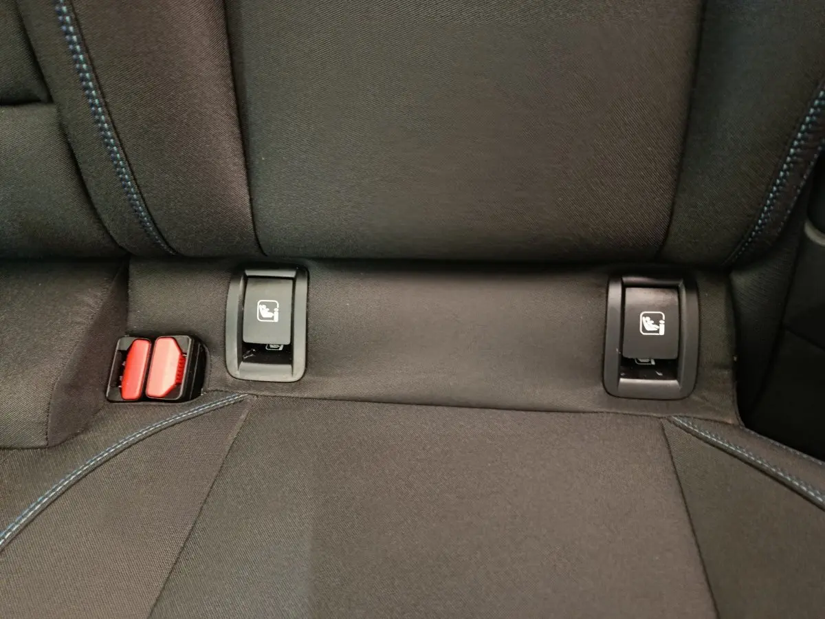 Détail des fixations ISOFIX sur la banquette arrière en tissu noir avec surpiqûres bleues du Link & Co 01 hybride rechargeable.