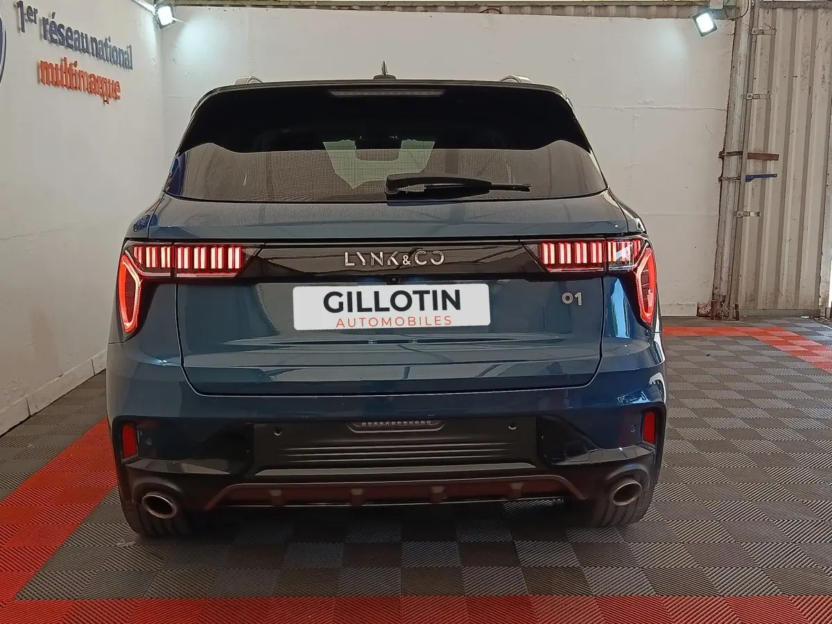 Vue arrière du SUV bleu LINK & CO 01 avec feux LED distinctifs et double sortie d’échappement en intérieur.