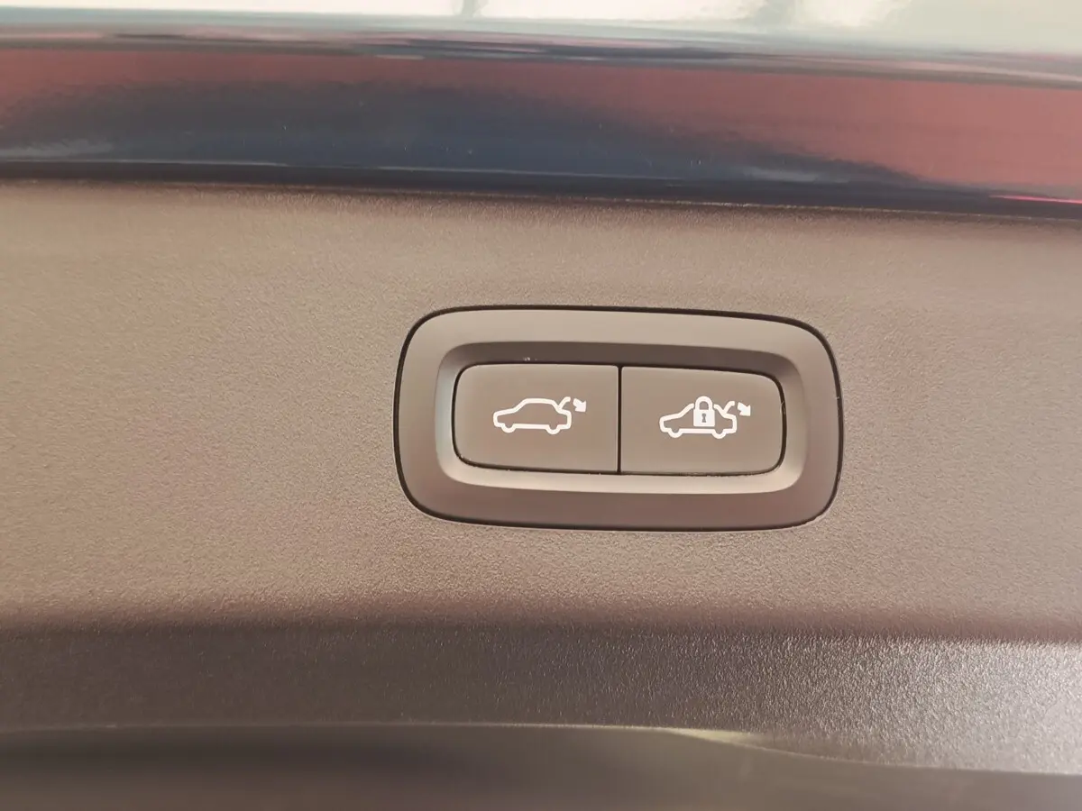 Gros plan sur les boutons d'ouverture et de verrouillage électrique du coffre du SUV bleu LINK & CO 01 hybride rechargeable.