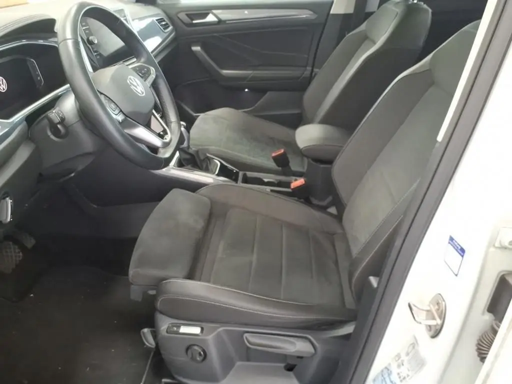 Vue intérieure côté conducteur du Volkswagen T-Roc 2022, sièges noirs en tissu et cuir, volant multifonction et tableau de bord moderne.