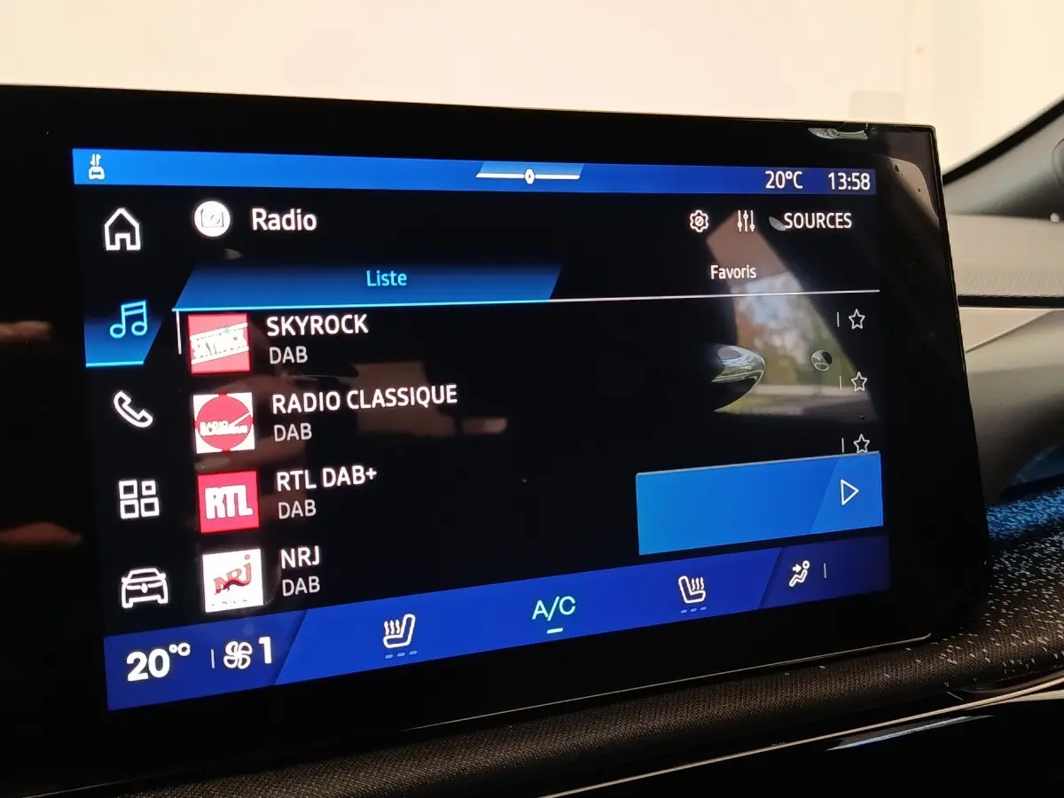 Écran tactile central de la Renault Clio Techno TCe 115 gris foncé, affichant les stations radio DAB.