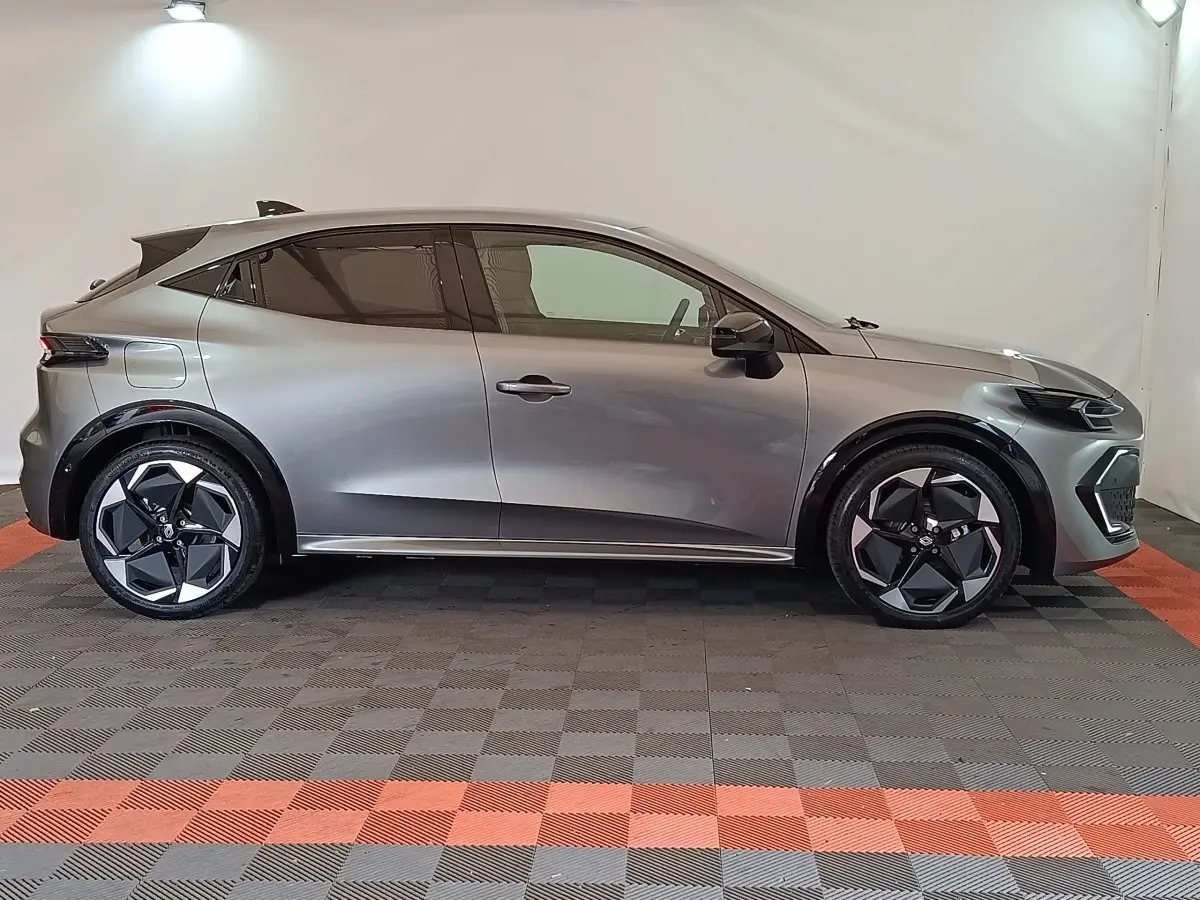 Profil droit de la Renault Clio Techno TCe 115 gris foncé avec jantes noires et détails noirs brillants.