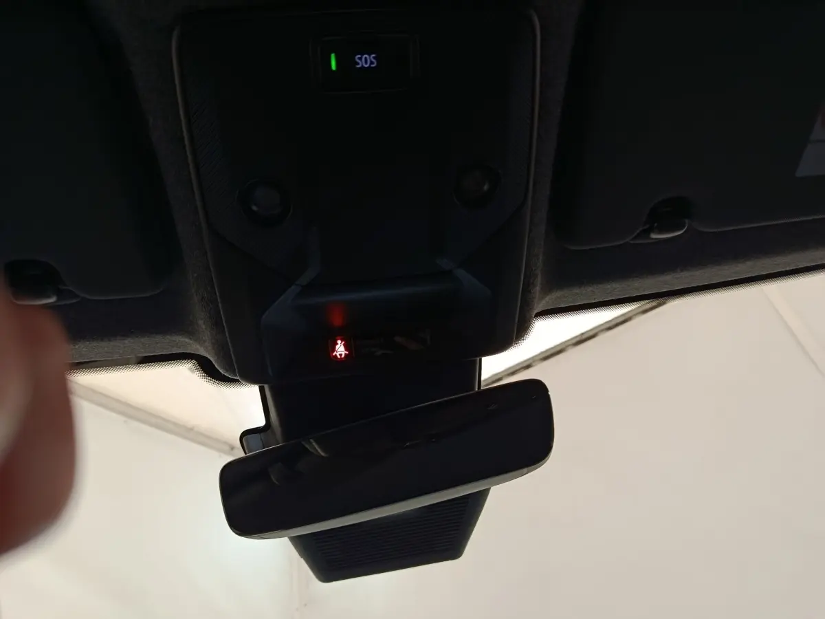 Vue intérieure du rétroviseur central et du plafonnier avec bouton SOS et indicateur de ceinture allumé, Renault Clio gris foncé.