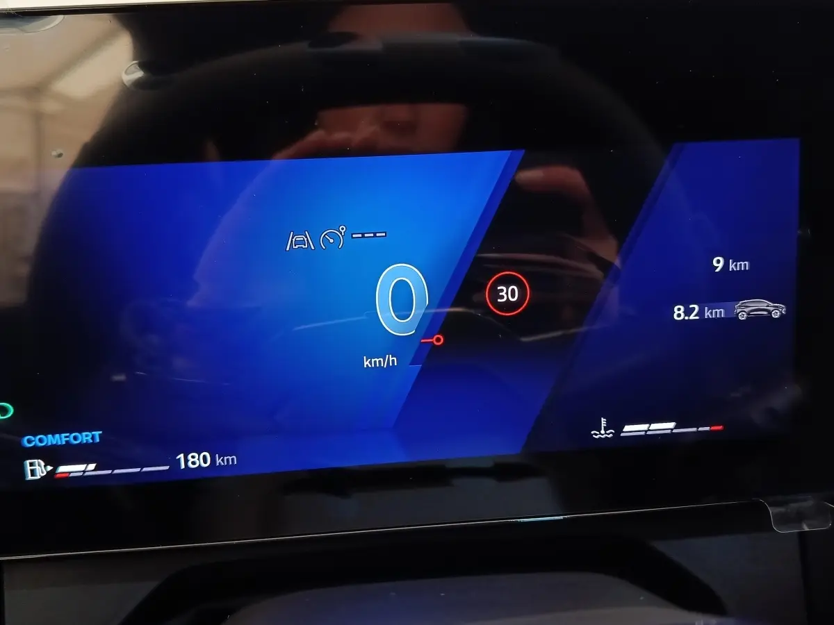 Affichage numérique du combiné d'instruments de la Renault Clio 2026, vue frontale sur écran bleu avec vitesse et alertes.