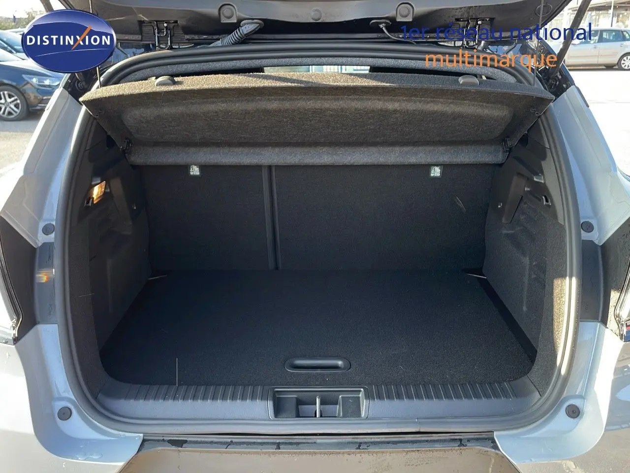 Coffre ouvert d'un Renault Captur E-Tech hybride 2025 gris Rafale métal avec toit noir, vue arrière détaillée.