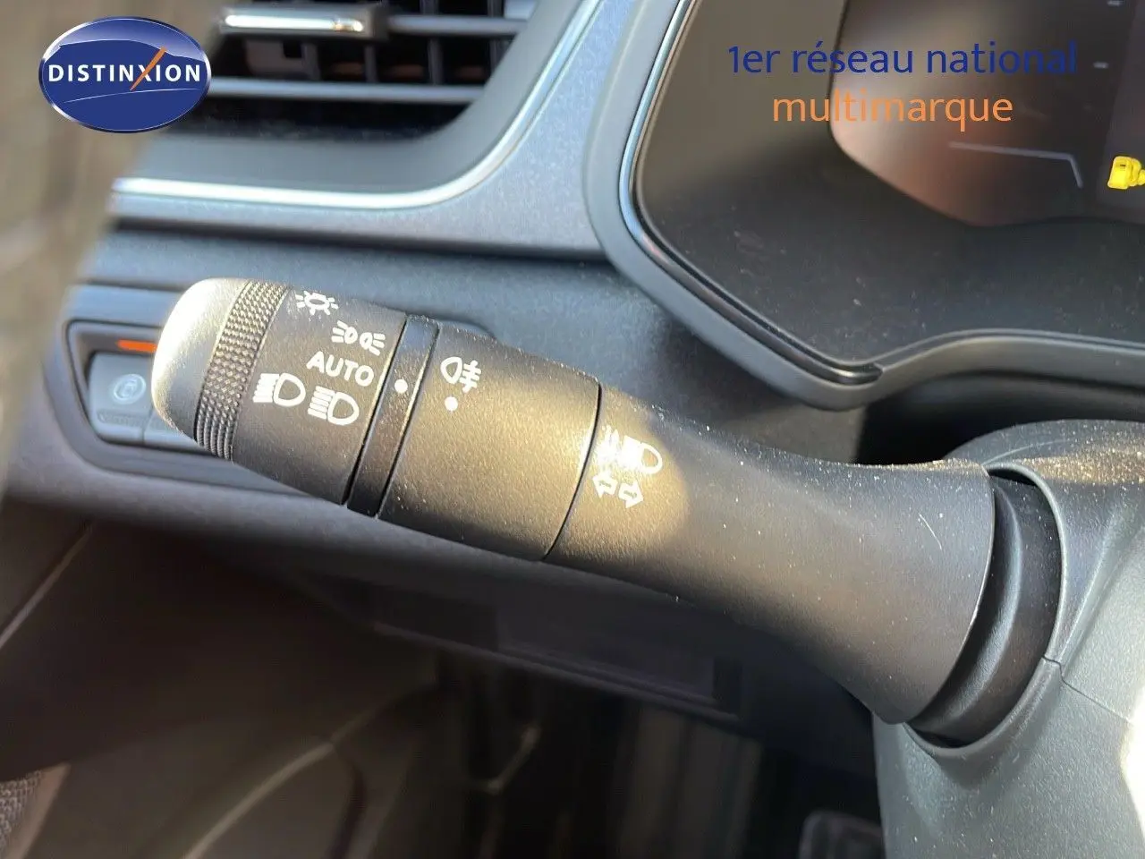 Gros plan sur la commande des feux du tableau de bord du Renault Captur E-Tech hybride 2025, intérieur gris.