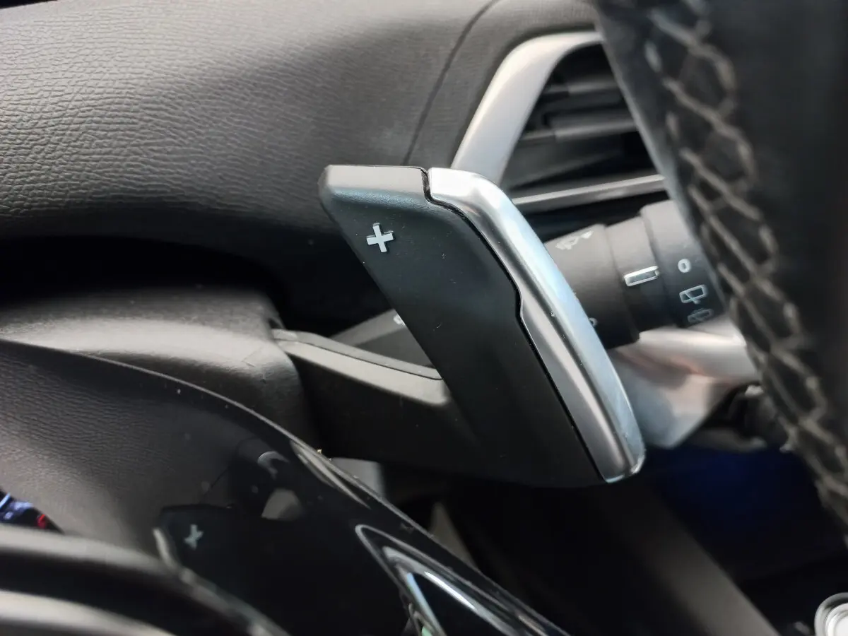 Gros plan sur la palette de changement de vitesse + côté droit du volant cuir noir du Peugeot 5008 gris foncé 2021.