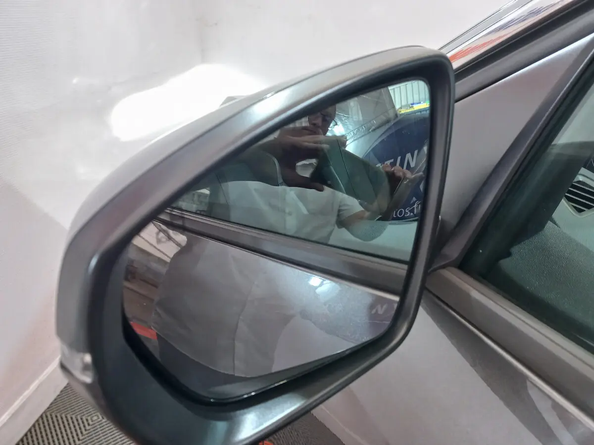 Rétroviseur extérieur côté gauche gris foncé du Peugeot 5008 2021, avec surface miroir et cadre plastique visible.