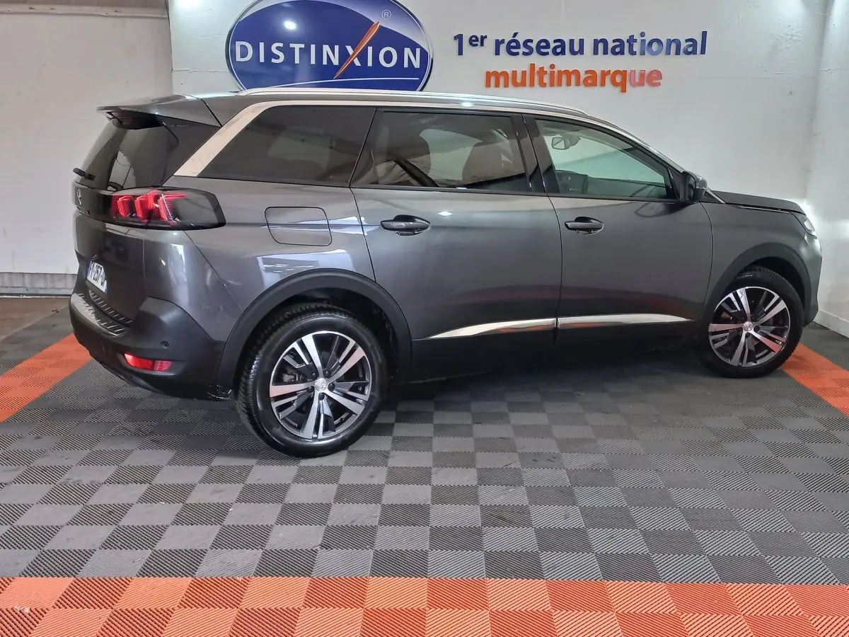 Peugeot 5008 gris foncé vue de profil côté droit, avec jantes alliage et feux arrière LED distinctifs.