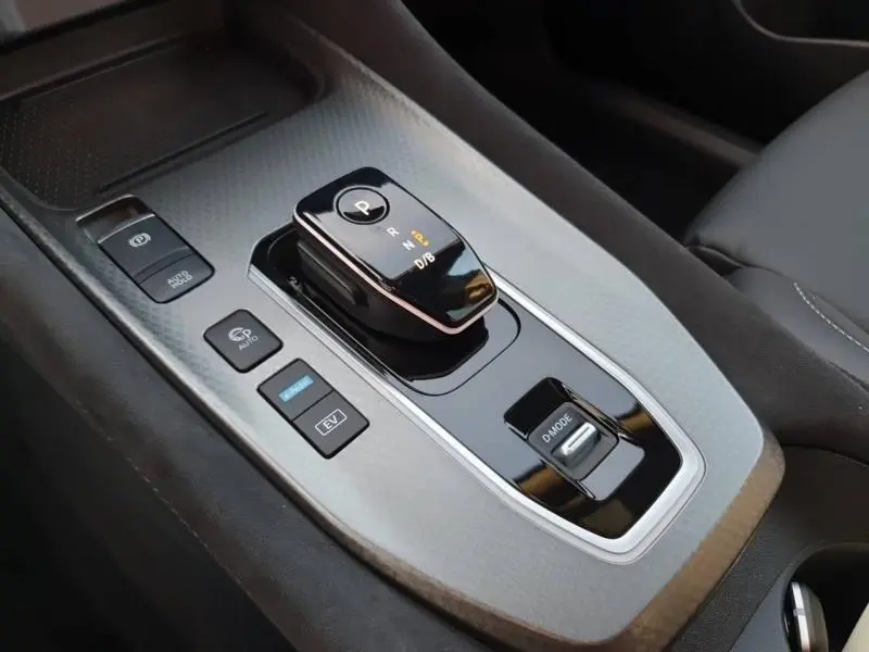 Vue rapprochée de la console centrale noire et grise avec levier de vitesse électronique du Nissan Qashqai Hybrid e-POWER 2025.