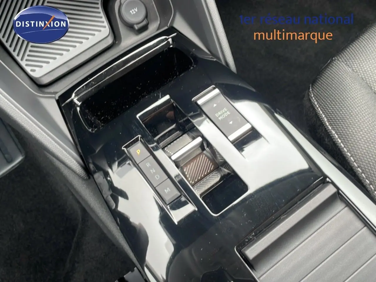 Vue rapprochée de la console centrale noire brillante avec sélecteur de boîte auto et bouton Drive Mode d'une Citroën C4 blanc métal.