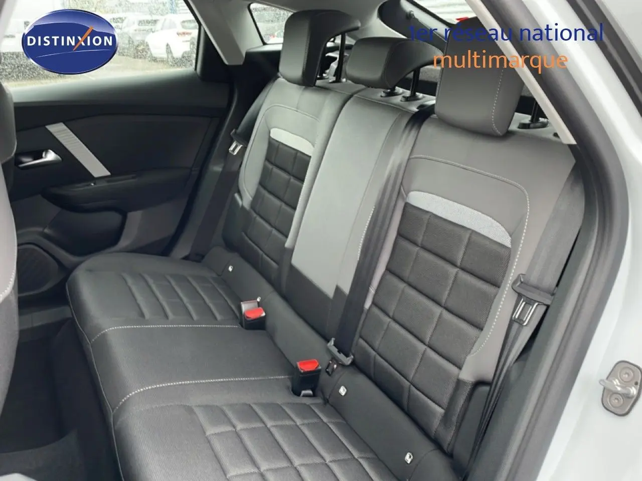 Vue intérieure côté arrière droit montrant les sièges arrière en tissu noir et gris d'une Citroën C4 blanc métal.