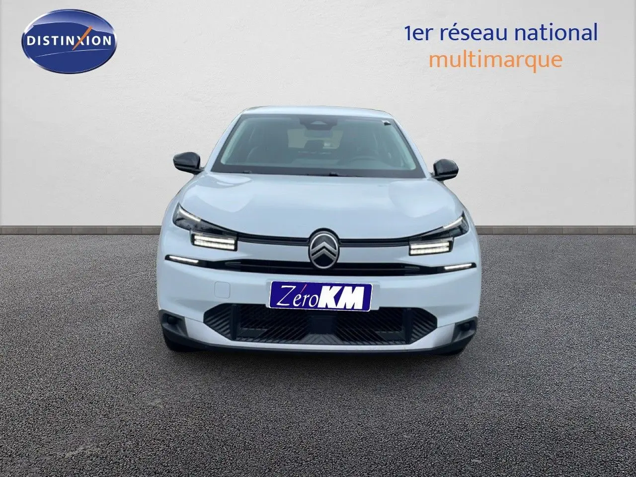 Vue frontale d'une Citroën C4 blanche métal avec phares LED allumés sur fond neutre.