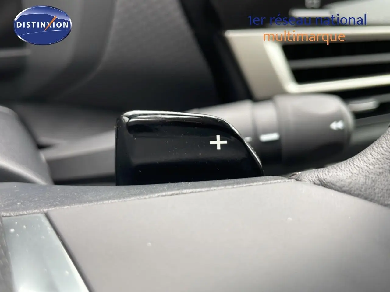 Gros plan sur la palette de changement de vitesse droite noire dans l’habitacle d’une Citroën C4 blanche.