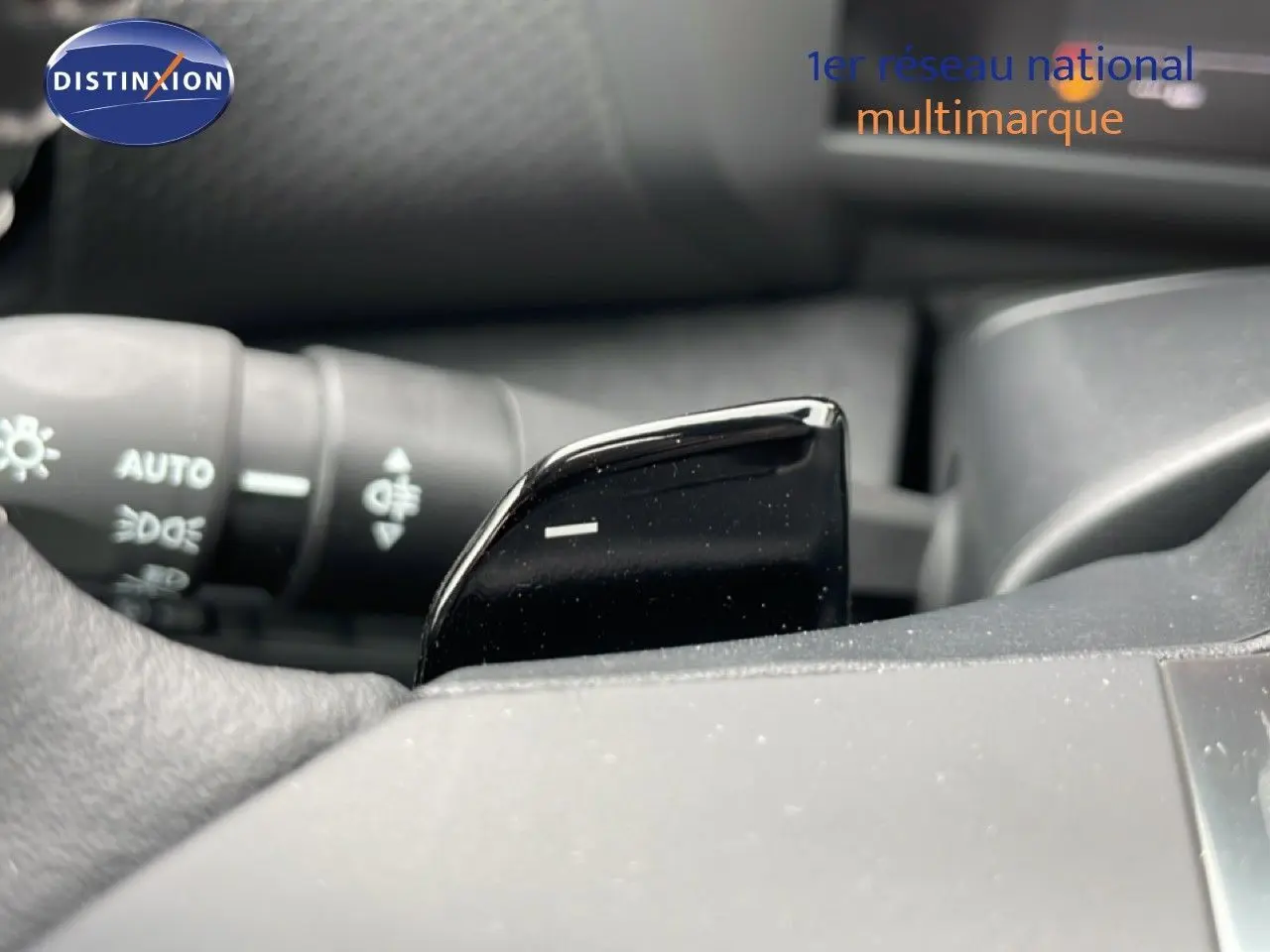 Gros plan sur la palette de changement de vitesse noire côté droit du volant d’une Citroën C4 blanche métal.