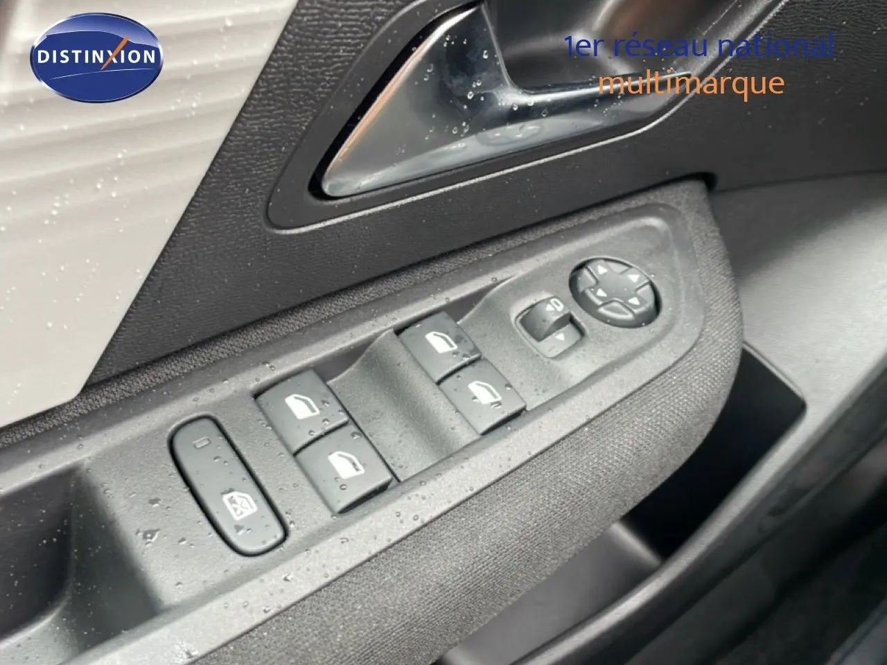 Gros plan sur les commandes de lève-vitres et rétroviseurs côté conducteur d'une Citroën C4 blanc métal.