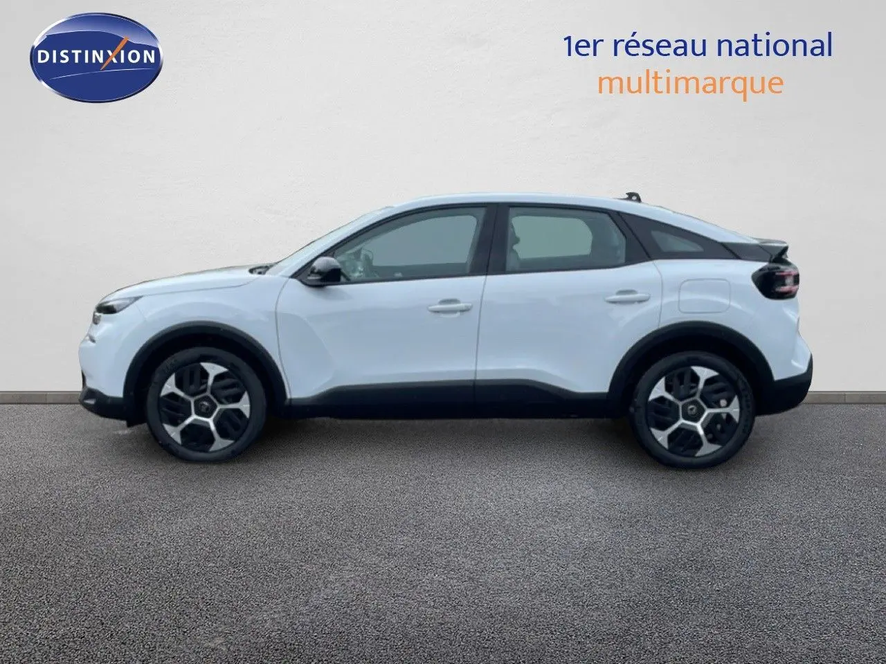 Vue de profil côté gauche d'une Citroën C4 blanc métal avec jantes alliage et toit noir contrasté.