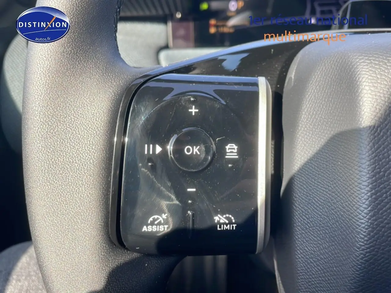Gros plan sur les commandes noires du volant multifonction du Citroën C5 Aircross blanc, version hybride 2026.