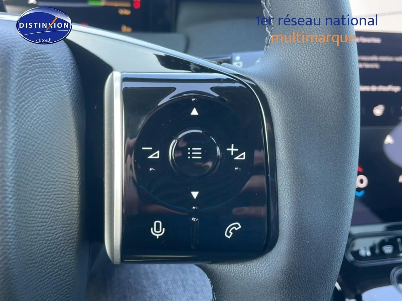Gros plan sur les commandes multifonctions noires à gauche du volant gris du Citroën C5 Aircross blanc 2026.