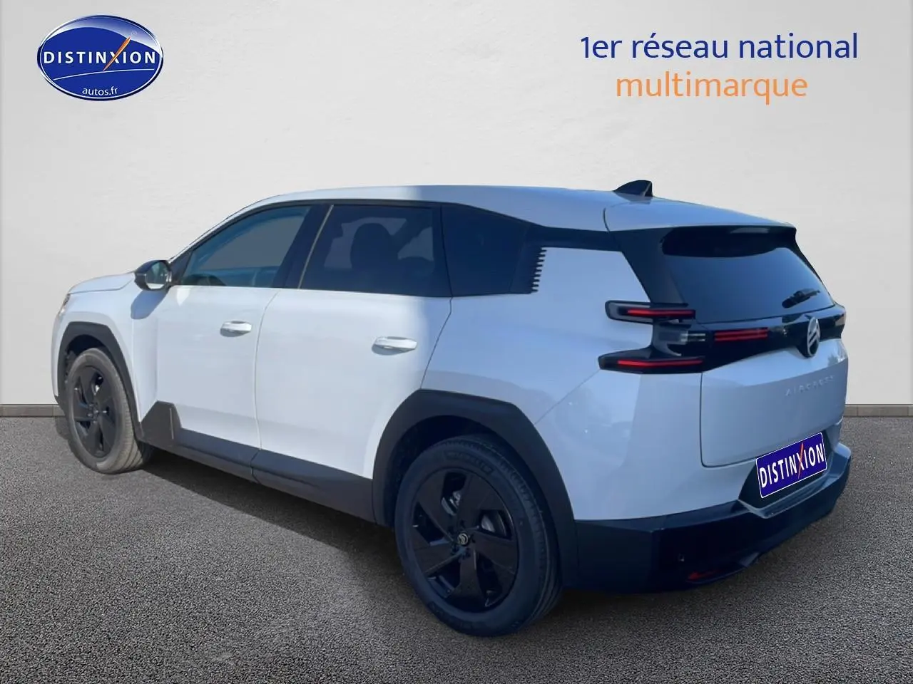 Vue 3/4 arrière droite du Citroën C5 Aircross blanc avec jantes noires et vitres arrière teintées.