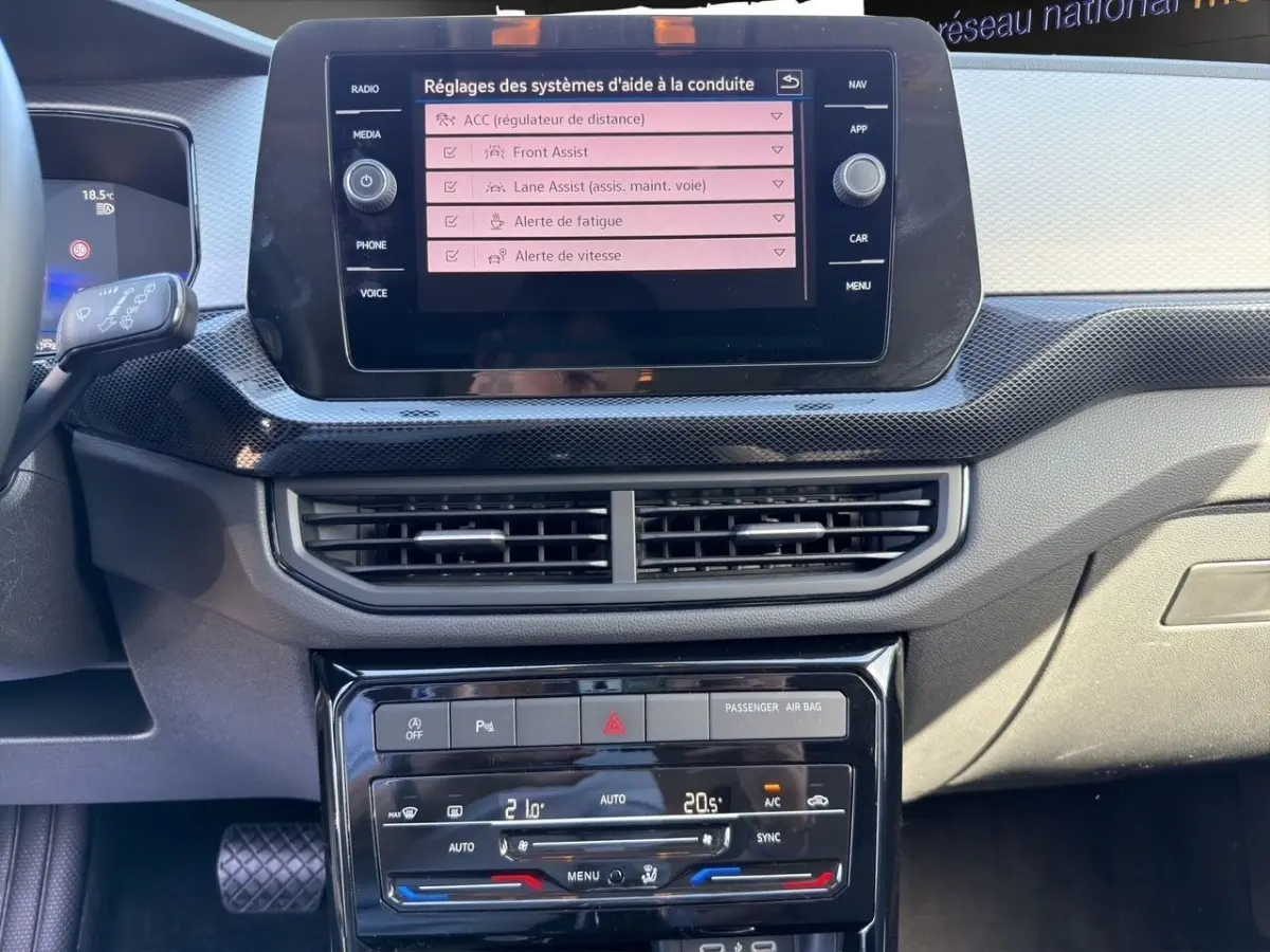 Vue rapprochée du tableau de bord du Volkswagen T-Cross 2025, écran tactile affichant les aides à la conduite.