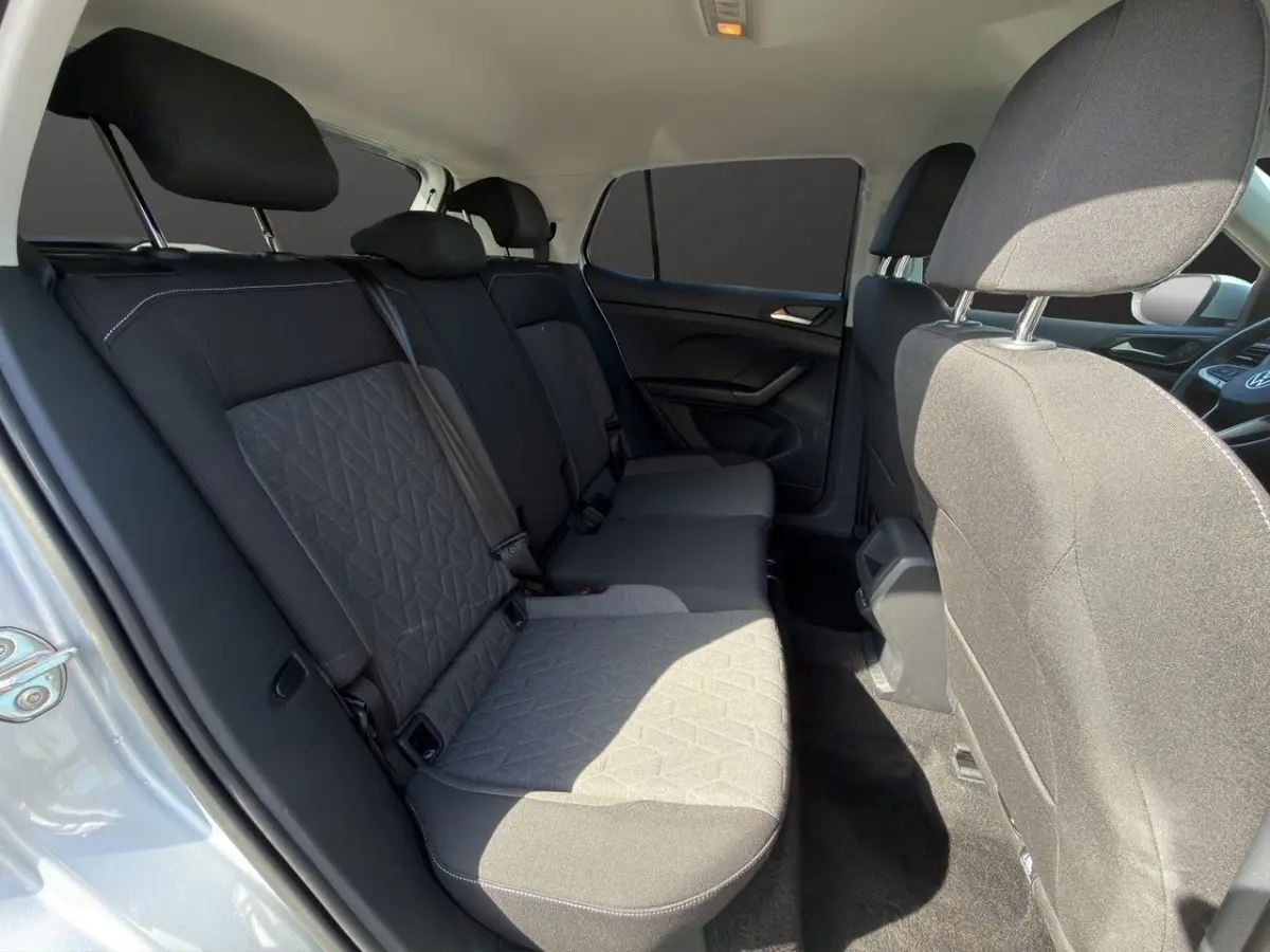 Vue intérieure côté droit montrant la banquette arrière grise du Volkswagen T-Cross 2025 avec tissu texturé.