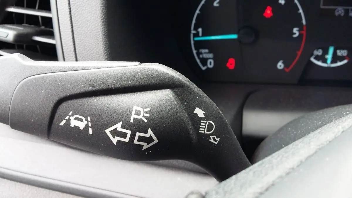 Gros plan sur le commodo de clignotants du Ford Transit Fourgon blanc, avec tableau de bord en arrière-plan.