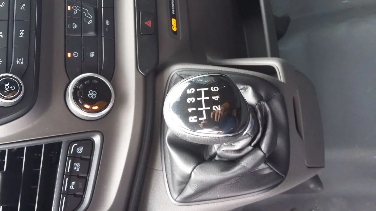 Le levier de vitesses manuel noir du Ford Transit Fourgon T350 blanc, avec console centrale et commandes visibles.