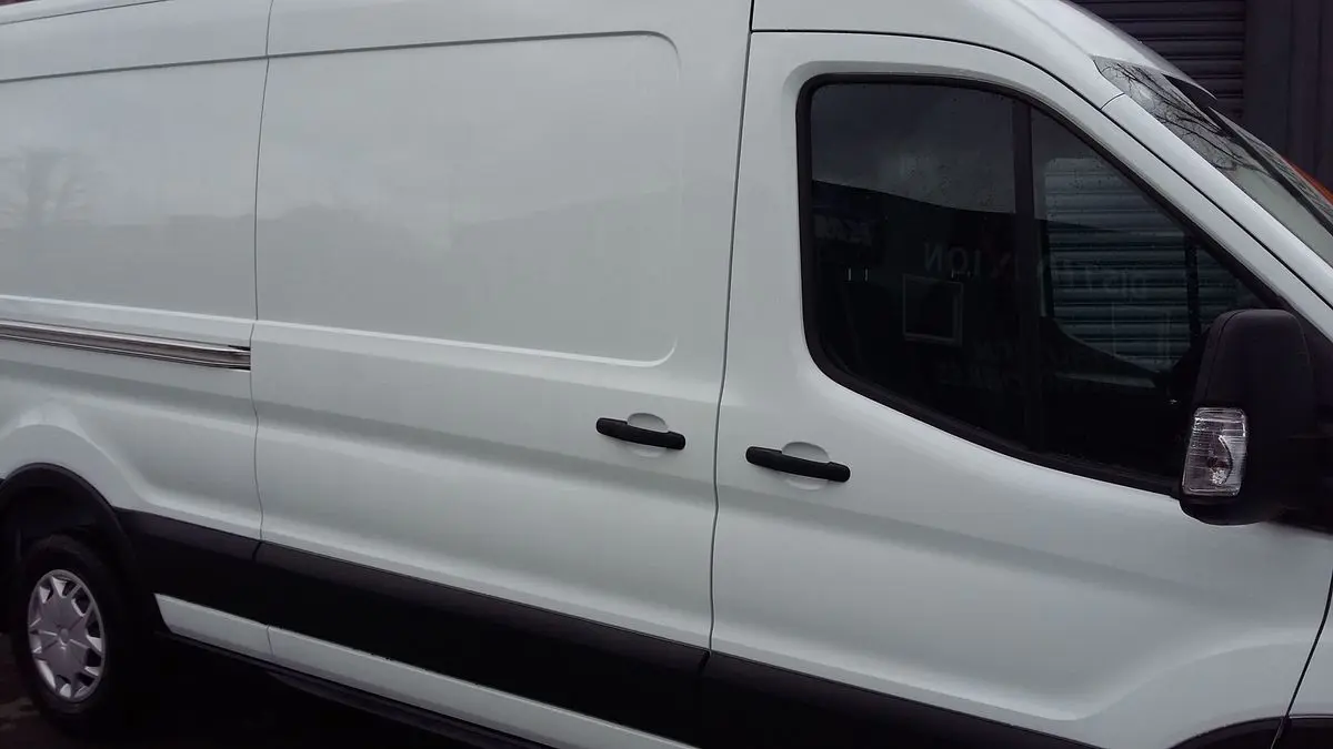 Vue latérale droite d'un Ford Transit Fourgon blanc glacier, mettant en valeur ses portes coulissantes et poignées noires.