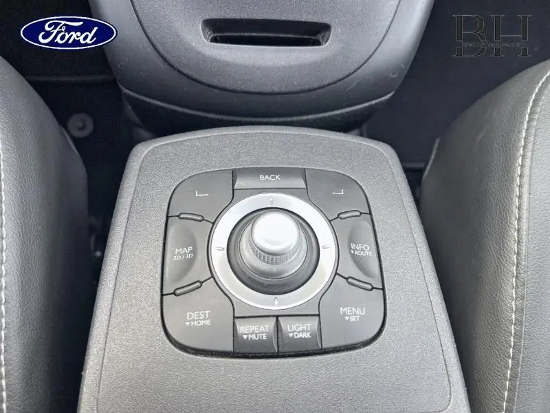 Gros plan sur la commande centrale noire du système multimédia d'un Renault Grand Scenic 1.5 dCi noir étoilé.