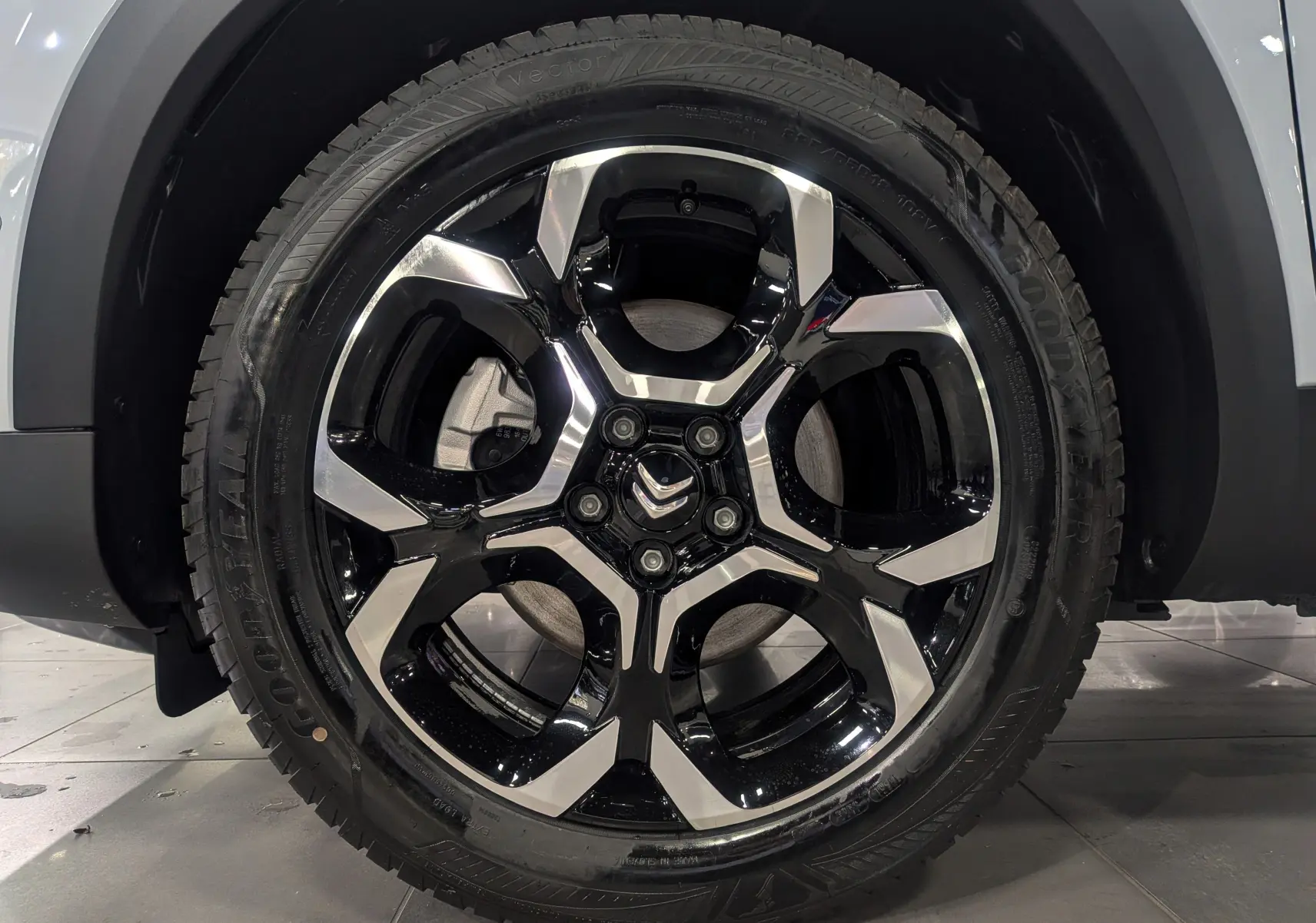 Gros plan sur la jante noire et argentée du Citroën C5 Aircross hybride 2025, avec logo Citroën au centre.