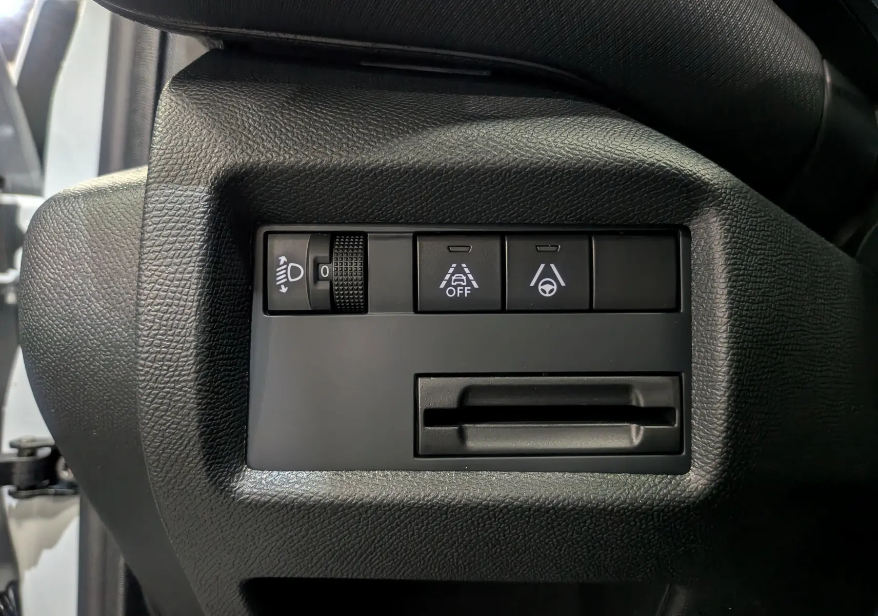 Gros plan sur les commandes d'assistance à la conduite du tableau de bord du Citroën C5 Aircross hybride blanc.