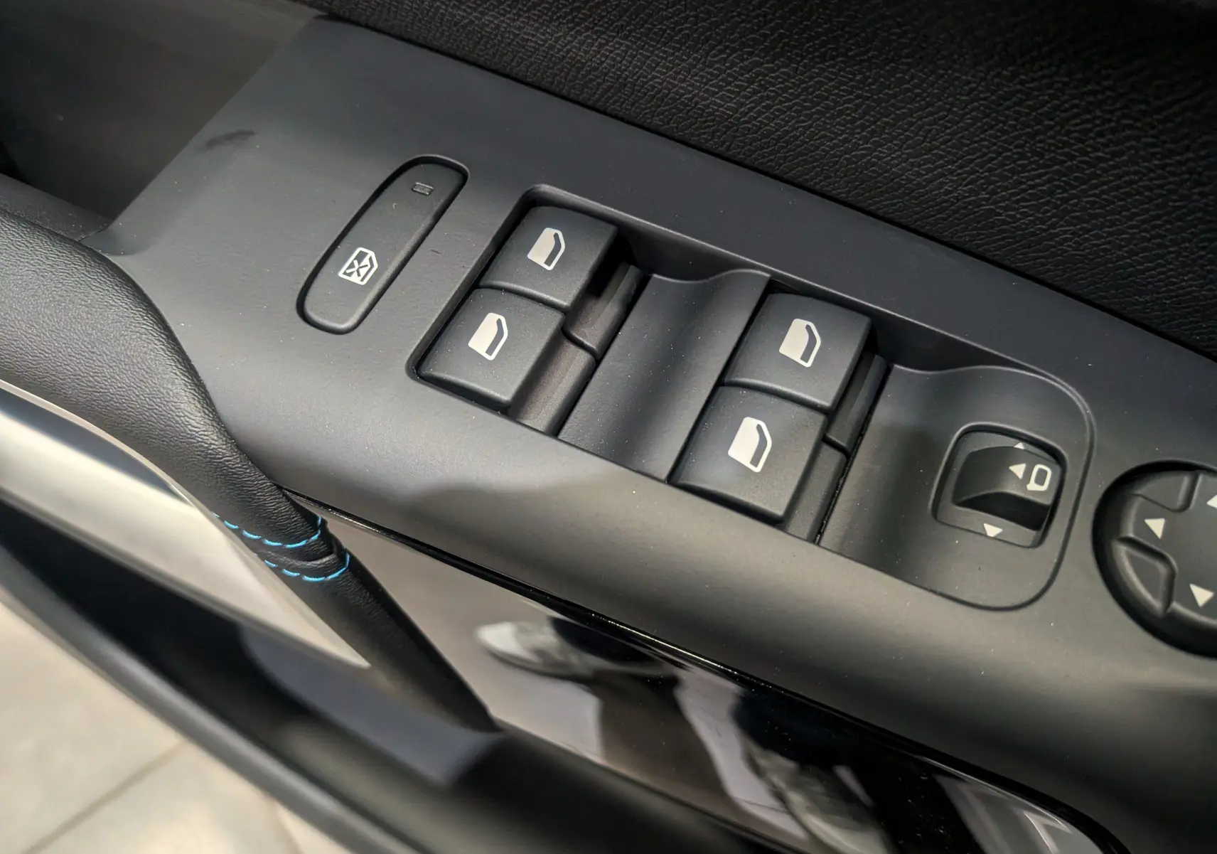 Gros plan sur les commandes des vitres électriques et rétroviseurs côté conducteur du Citroën C5 Aircross hybride 2025.